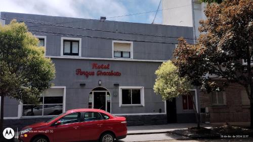 a red car parked in front of a building at Parque Chacabuco in Mar del Plata