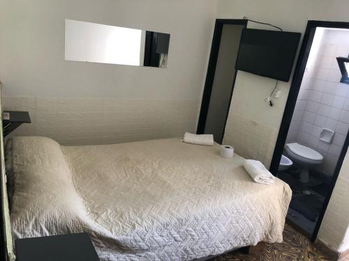 a bedroom with a bed and a mirror and a toilet at Parque Chacabuco in Mar del Plata