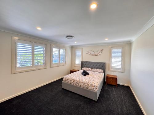 a bedroom with a bed and windows at Blue Haven Retreat - Jordan Springs in Kingswood