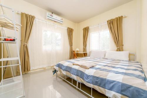 een slaapkamer met een blauw en wit bed en ramen bij Full house 2BR near Bus station North Pattaya in Pattaya