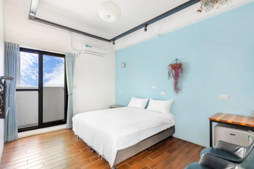 a bedroom with a bed and a desk and a chair at 25Inn Hengchun Kenting in Nanwan