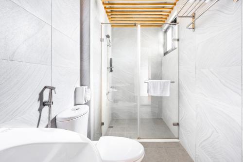 a white bathroom with a shower and a toilet at 25Inn Hengchun Kenting in Nanwan