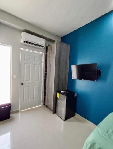 a room with a white door and a blue wall at Casa azul in Tecomán