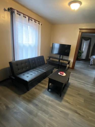 a living room with a black couch and a table at Casa ubicada 6 minutos del centro 6 minutes to Downtow No permited partys or smoking in Milwaukee