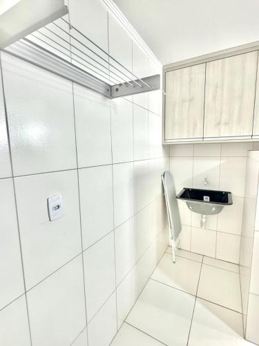 a white bathroom with a sink and a mirror at Studio Charmoso e Aconchegante em Itaberaba in Itaberaba