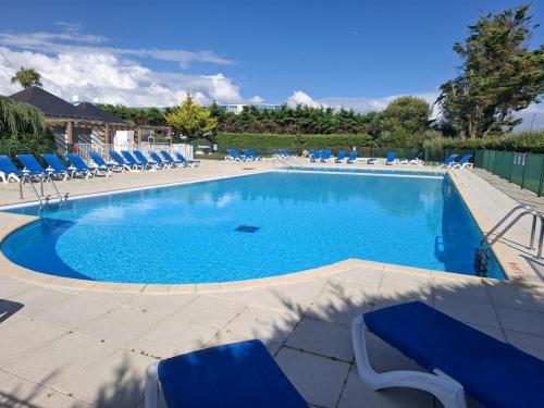 - une grande piscine avec des chaises longues bleues dans un complexe dans l'établissement Appartement pour 5 pers. avec terrasse et accès piscine à Arzon - FR-1-639-17, à Arzon