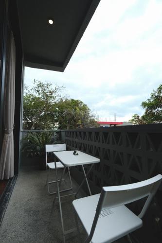 two white tables and chairs on a balcony at Lux Sea Studio 1 in San Juan