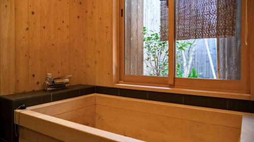 e bagno in legno con finestra e vasca. di 京一軒町家 染 SEN 七条壬生 Shichijo-Mibu a Kyoto