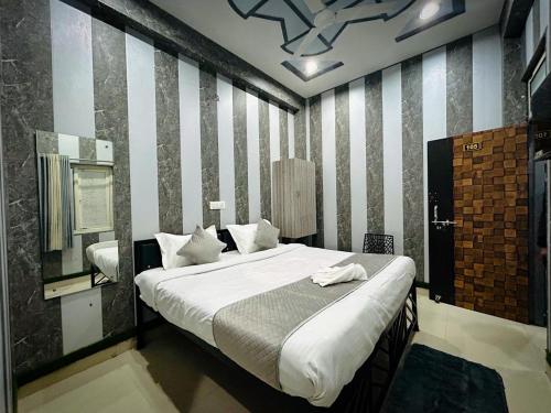 a bedroom with a large bed and a mirror at SHARVIL Inn in Lucknow