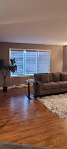 a living room with a couch and a table at Rustyc Charm Meets Modern Comfy in Dieppe