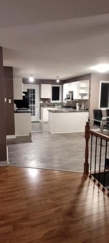 a large kitchen and living room with wooden floors at Rustyc Charm Meets Modern Comfy in Dieppe