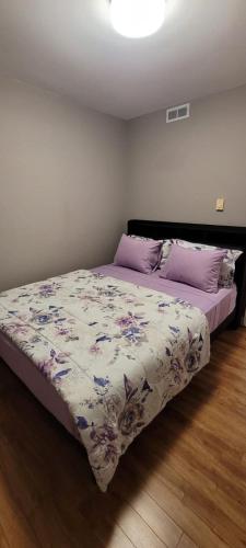 a bedroom with a bed with a floral comforter at Rustyc Charm Meets Modern Comfy in Dieppe