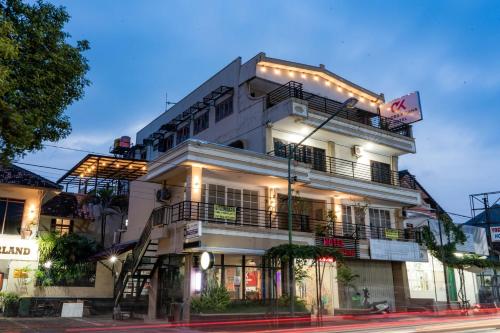 a white building with lights on the side of it at Hotel Candra Kirana Syariah Prawirotaman Yogyakarta Mitra RedDoorz in Yogyakarta
