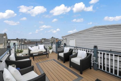 a deck with chairs and tables on a balcony at The Inn At Ocean Grove in Ocean Grove
