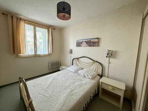 une chambre avec un lit blanc et une fenêtre dans l'établissement APPARTEMENT AVEC TERRASSE PROCHE PLAGE - FR-1-652-49, à Saint-Hilaire-de-Riez