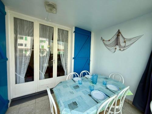 une salle à manger avec une table et des chaises bleues dans l'établissement APPARTEMENT AVEC TERRASSE PROCHE PLAGE - FR-1-652-49, à Saint-Hilaire-de-Riez