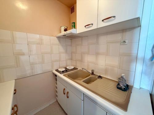 Elle comprend une petite cuisine avec un évier et des placards blancs. dans l'établissement APPARTEMENT AVEC TERRASSE PROCHE PLAGE - FR-1-652-49, à Saint-Hilaire-de-Riez