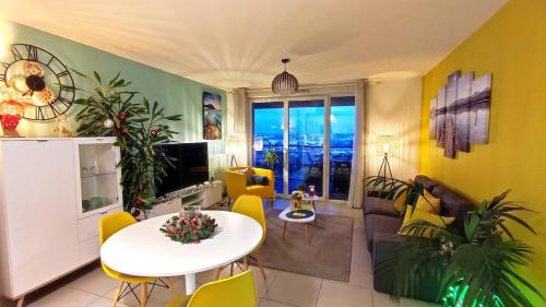 d'un salon avec une table blanche et des murs jaunes. dans l'établissement T3 Panoramic view Toulouse, near Chu Rangueil, 2 chambres, tout équipé, neuf, à Toulouse