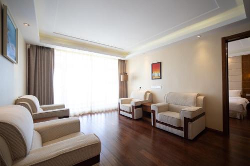a hospital room with chairs and a bed and a mirror at Wanda Yue Hotel Changbaishan Chixi in Xinancha
