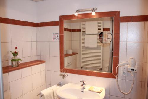 a bathroom with a sink and a mirror at Wüllner's Landgasthof in Schmallenberg