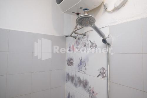 a shower with a shower head in a bathroom at Hotel Candra Kirana Syariah Prawirotaman Yogyakarta Mitra RedDoorz in Yogyakarta