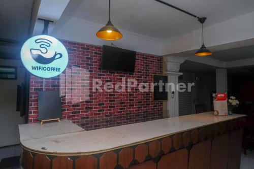 a bar with a sign on a brick wall at Hotel Candra Kirana Syariah Prawirotaman Yogyakarta Mitra RedDoorz in Yogyakarta