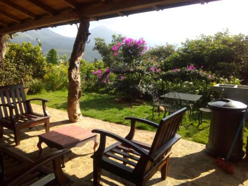 a patio with two chairs and a trash can at cabaña Lechuza café in Juayúa