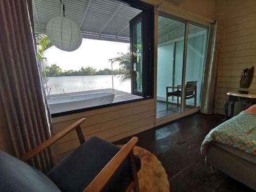 a room with a view of the water and a tub at บ้านพระจันทร์เวียน - House of moon phase in Chachoengsao