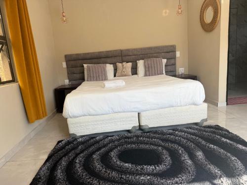 a bedroom with a large bed with a large carpet at Horizon Bed and Breakfast in Roodepoort