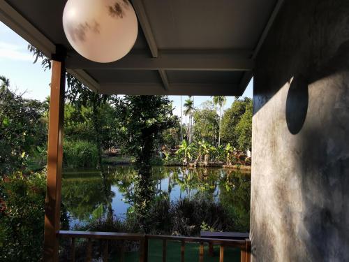 a view of a pond from the porch of a house at บ้านพระจันทร์เวียน - House of moon phase in Chachoengsao