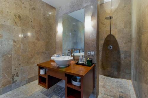 a bathroom with a sink and a mirror at The Residence Seminyak in Seminyak