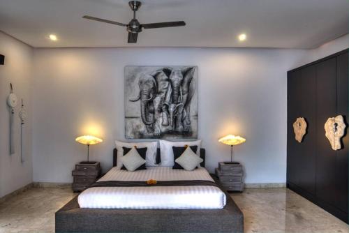 a bedroom with a bed with a painting on the wall at The Residence Seminyak in Seminyak