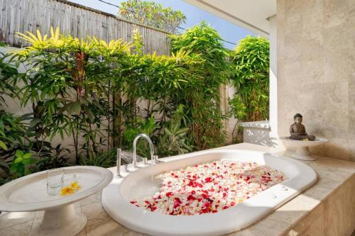 a bathroom with two sinks and a bath tub at The Residence Seminyak in Seminyak