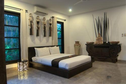 a bedroom with a bed and a dresser in it at The Residence Seminyak in Seminyak