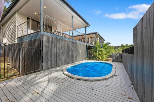 a swimming pool on the deck of a house at Blue Haven in Kianga