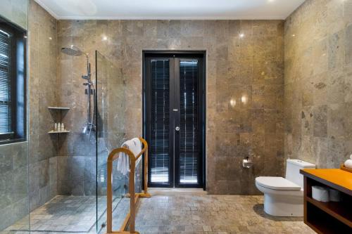 a bathroom with a shower and a toilet at The Residence Seminyak in Seminyak