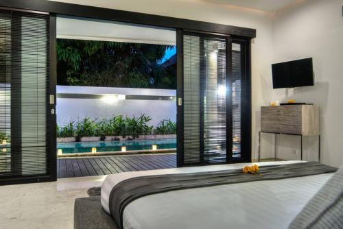 a bedroom with a large bed and a view of a pool at The Residence Seminyak in Seminyak