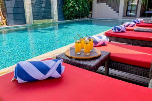 a table with drinks on it next to a swimming pool at The Residence Seminyak in Seminyak