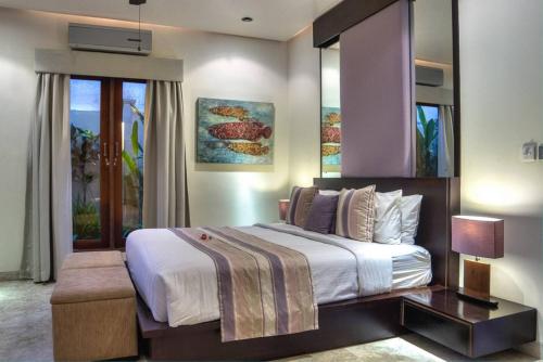 a bedroom with a large bed and a large window at The Residence Seminyak in Seminyak