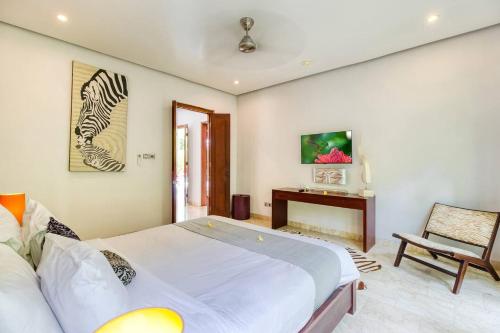 a bedroom with a large bed and a chair at The Residence Seminyak in Seminyak