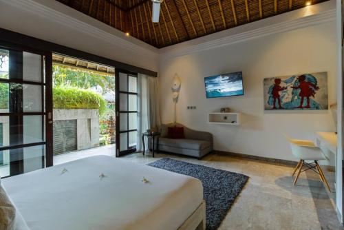 a bedroom with a large white bed and a couch at The Residence Seminyak in Seminyak