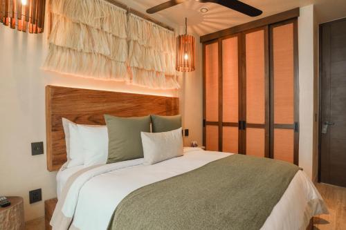 a bedroom with a large bed in a room at Trobbu Boutique Collection Tulum - All inclusive in Tulum