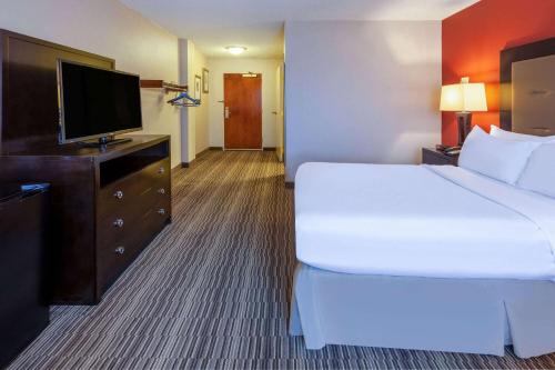 a hotel room with a bed and a flat screen tv at Randolph Hotel Liverpool Syracuse Airport West, Trademark in Liverpool