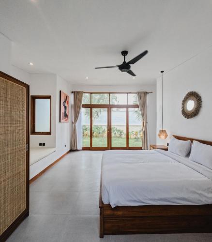 a bedroom with a bed and a ceiling fan at Maravilla Complex in Nusa Penida