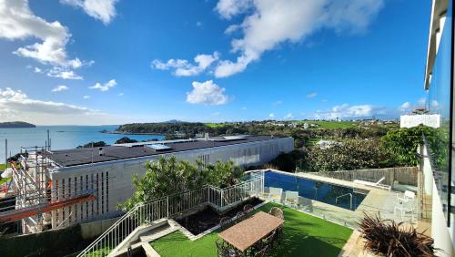 arial view of a building with a view of the ocean at Orakei Grandeur Mansion with Sea Views & Pool in Auckland