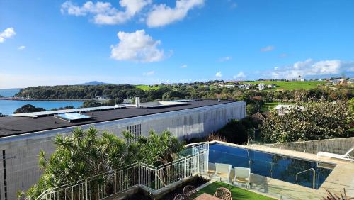 a building with a view of a body of water at Orakei Grandeur Mansion with Sea Views & Pool in Auckland