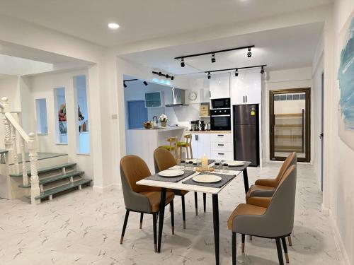 a kitchen and dining room with a table and chairs at G Cozy Pool Villa in Pattaya South