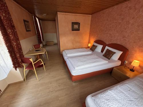 a hotel room with two beds and a table and chairs at Black Forest Hotel Todtnau in Todtnau