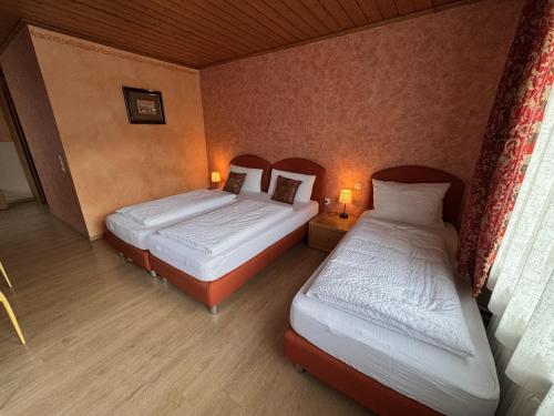 two twin beds in a room with two lamps at Black Forest Hotel Todtnau in Todtnau