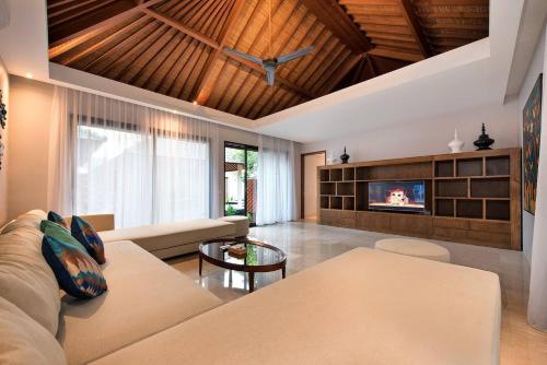 a living room with a couch and a tv at Karang Saujana in Uluwatu
